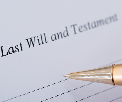 Cropped image of hand signing Last Will and Testament document